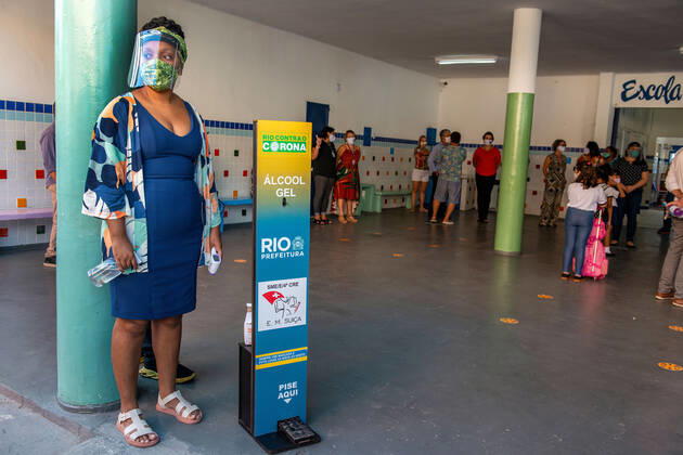 COVID-19 Back To School RIO DE JANEIRO, BRAZIL, FEB 24: COVID-19 BACK TO SCHOOL- Public elementary schools reopen after almost a year of pandemic recess. Teacher waits for students to check their temperature and sanitize hands at school entrance on February 24, 2021. ( Photo by Chico Ferreira Penta Press ) Rio de Janeiro Brazil 6203_232800 Copyright: xChicoxFerreira PentaxPressx