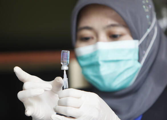 COVID-19 vaccination Second phase to In Bogor, Indonesia A medical worker prepares to inject a dose of COVID-19 vaccine during a mass vaccination in Bogor on February 25, 2021. Indonesia has started the second phase of a national COVID-19 vaccination campaign, one million people in Indonesia have been inject a vaccine. 