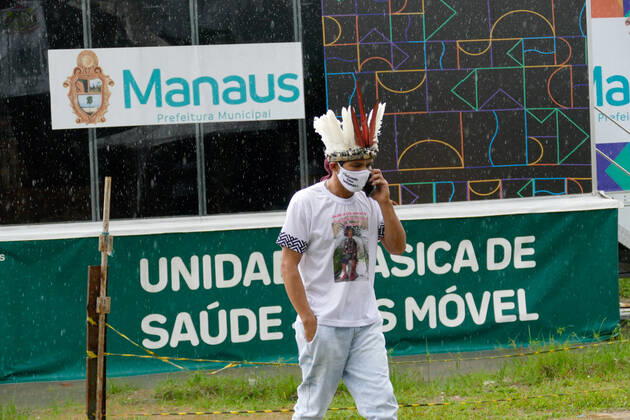 MANAUS, AM - 25.02.2021: ÍNDIOS DE 70 E MAIS SÃO VACINADOS MANAUS - Indigenous people aged 70 and over, from the Parque das Tribos community in Manaus (AM), are vaccinated this Thursday morning (25), with the AstraZeneca Oxford immunizer. Nurses are also doing CRP testing on indigenous people with Covid-19 symptoms. In the photo, we wear a headdress, Chief Micah Kokama. x2036040x  SandroxPereira