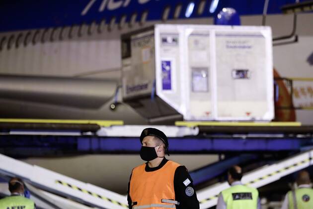 Security personnel control the unloading of containers with the cargo of 904,000 doses of the Sinopharm vaccine against covid-19 from China of an Argentinas Airlines plane, after landing at the Ezeiza airport, in Buenos Aires, Argentina, 25 February 2021. These doses that arrived from China are added to the 1.8 million doses arrived from Russia and India with which the population is already being inoculated, while the scandal over the VIP vaccination of figures linked to the Government worsens. Argentina receives 904,000 doses of Sinopharm vaccine from China !ACHTUNG: NUR REDAKTIONELLE NUTZUNG!  Copyright: xJuanxIgnacioxRoncoronix AME8222 20210226-637499085684329868