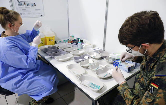 Impfzentrum Schoenefeld Schoenefeld, DEU, 26.02.2021 - Spritzen werden von Soldaten der Bundeswehr mit dem Covid19 Biontech Pfizer Impfstoff Comirnaty befuellt, im Impfzentrums am Terminal 5 des BER Flughafens. Schoenefeld Brandenburg Deutschland