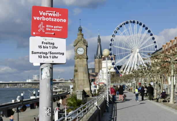 Bilder des Jahres 2021, News 02 Februar News Themen der Woche KW08 News Bilder des Tages F95 - H96 Düsseldorf, NRW 26.2.2021, Corona, Bitte gehen Sie weiter: Aufgrund der Menschenansammlungen am vergangenen Wochenende hat die Stadt Düsseldorf ein Verweilverbot für die Rheinuferpromenade in der Altstadt festgelegt. Dieses gilt an Freitagen von 15:00 Uhr bis 1:00 Uhr und an Sa So. von 10:00 bis 1:00 Uhr. Noch ist es 14:50 am Freitag und Menschen nutzen die Zeit auf den Parkbänken.