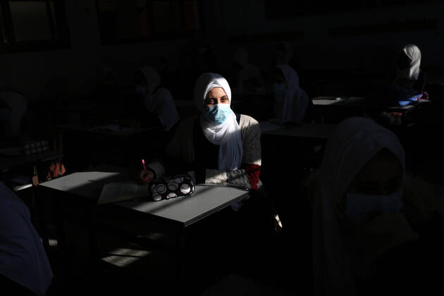 February 27, 2021, Gaza city, Gaza Strip, Palestinian Territory: Palestinian students wearing protective face masks, sit in a classroom, in the morning of the first day of the second semester study, amid the coronavirus disease (COVID-19) outbreak, at their school, in Dair Al Balah in the central of Gaza Strip, on February 27, 2021 Gaza city Palestinian Territory - ZUMAap3_ 20210227_zaf_ap3_074 Copyright: xAshrafxAmrax