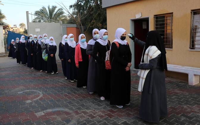 February 27, 2021, Gaza city, Gaza Strip, Palestinian Territory: Palestinian students wearing protective face masks, return back to their school, in the morning of the first day of the second semester study, amid the coronavirus disease (COVID-19) outbreak, in Dair Al Balah in the central of Gaza Strip, on February 27, 2021 Gaza city Palestinian Territory - ZUMAap3_ 20210227_zaf_ap3_107 Copyright: xAshrafxAmrax