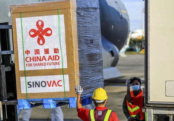 (210228) -- MANILA, Feb. 28, 2021 -- Staff members unload vaccines donated by China at a Philippine Air Force base in Manila, the Philippines, on Feb. 28, 2021. A batch of Sinovac vaccine CoronaVac donated by China arrived in the Philippines on Sunday, the first COVID-19 vaccine to reach the Southeast Asian country. The delivery of the vaccines allows the Philippines to start mass vaccinations soon, marking a new phase in the country s fight against the COVID-19 that infected 576,352 and killed 12,318. ) PHILIPPINES-MANILA-COVID-19-VACCINE-ARRIVAL ROUELLExUMALI 