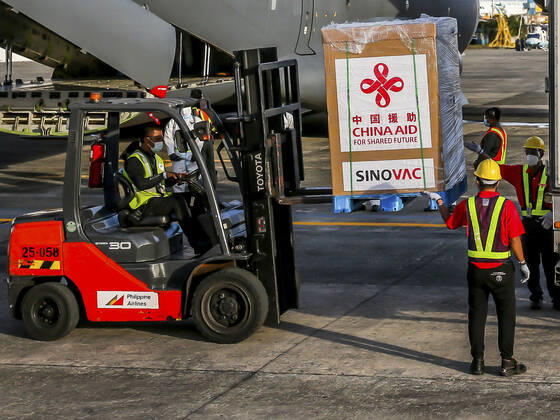 (210228) -- MANILA, Feb. 28, 2021 -- Staff members unload vaccines donated by China at a Philippine Air Force base in Manila, the Philippines, on Feb. 28, 2021. A batch of Sinovac vaccine CoronaVac donated by China arrived in the Philippines on Sunday, the first COVID-19 vaccine to reach the Southeast Asian country. The delivery of the vaccines allows the Philippines to start mass vaccinations soon, marking a new phase in the country s fight against the COVID-19 that infected 576,352 and killed 12,318. ) PHILIPPINES-MANILA-COVID-19-VACCINE-ARRIVAL ROUELLExUMALI 