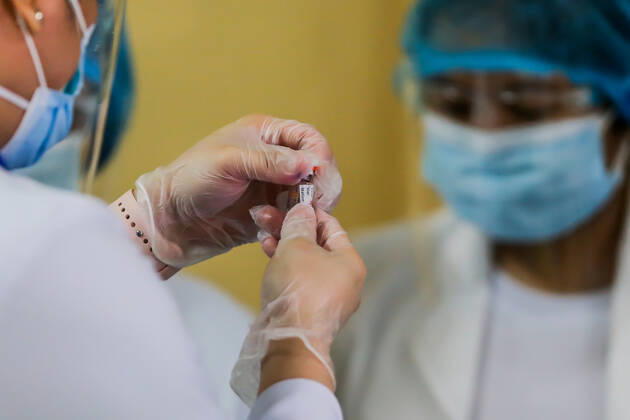 (210301) -- MANILA, March 1, 2021 -- A doctor looks at a vial of COVID-19 vaccine from China s Sinovac on the first day of the vaccination at the Lung Center of the Philippines in Manila, the Philippines on March 1, 2021. The Philippines launched its coronavirus vaccination campaign on Monday, less than a day after the arrival of the Sinovac vaccine CoronaVac donated by China. ) PHILIPPINES-MANILA-COVID-19-VACCINATION ROUELLExUMALI 