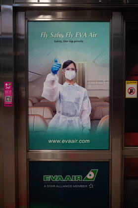 28.02.2021, Singapur, Republik Singapur, Asien - Ein Werbeplakat am Bahnsteig eines MRT U-Bahnhofs wirbt inmitten der anhaltenden Corona-Krise (Covid-19) fuer sichere Flugreisen mit der taiwanesischen Fluggesellschaft EVA AIr.