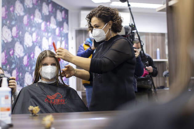 01.03.2021 , DU Duisburg , Friseure dürfen ab dem 01.03.2021 wieder öffnen , Sadiye Kisin vom Friseursalon Haarscharf in Duisburg - Buchholz hat den ersten Termin in ihrem Salon am Marktplatz um 00:01 Uhr versteigert. SPD-Landtagspolitikerin Sarah Philipp hat mit ihrem Gebot von 500 Euro gewonnen , Kisin verdoppelt den Betrag , insgesamt gehen 1000 Euro an die Kindernothilfe in Duisburg. Friseurin Sadiye Kisin schneidet Sarah Philipp die Haare.