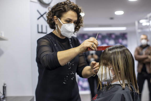 01.03.2021 , DU Duisburg , Friseure dürfen ab dem 01.03.2021 wieder öffnen , Sadiye Kisin vom Friseursalon Haarscharf in Duisburg - Buchholz hat den ersten Termin in ihrem Salon am Marktplatz um 00:01 Uhr versteigert. SPD-Landtagspolitikerin Sarah Philipp hat mit ihrem Gebot von 500 Euro gewonnen , Kisin verdoppelt den Betrag , insgesamt gehen 1000 Euro an die Kindernothilfe in Duisburg. Friseurin Sadiye Kisin schneidet Sarah Philipp die Haare.