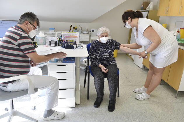 Doctor Jiri Bartos, left, and an elderly woman, center, who receives a vaccine against the covid-19, at the surgery office in Moravska Nova Ves in Breclav region, Czech Republic, March 1, 2021. (CTKxPhoto VaclavxSalek) CTKPhotoP202103010743901  sal 05