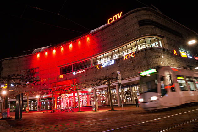 Kassel Einkaufszentren in Kassel leuchten rot Einkaufszentren in Kassel leuchten rot, das City-Center in der Innenstadt Kassel leuchtert rot als ein mahnendes Zeichen für die schwierige Lage der Händler sowie für eine schnelle Wiedereröffnung der Geschäfte in Deutschland, die Lichtaktion findet im Rahmen der Initiative Das Leben gehört ins Zentrum statt, zu der sich zahlreiche namhafte Handelsunternehmen zusammengeschlossen haben, 1. März 2021, Kassel Hessen Deutschland,