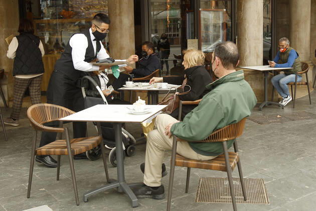 A waiter serves several customers on the terrace of a bar in Palma, Majorca, Balearic Islands, Spain, March 2, 2021. Mallorca receives this Tuesday new measures relating to hospitality and social gatherings. Thus, bars and restaurants on the island will be able to reopen their terraces and social gatherings may be up to six people. 02 MARCH 2021;MALLORCA;FORMENTERA;BALEARIC ISLANDS;HOTEL AND CATERING TRADE Isaac Buj LagenciaEP 03 02 2021 PALMA, MALLORCA, BALEARIC ISLAND PALMA, MALLORCA, BALEARIC ISLAND Spain Copyright: xIsaacxBujx 3588003