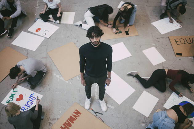 Portrait of man standing while male and female preparing signboards in building Sweden, Stockholm, model released, property released Copyright: xMaskotx , MA84507