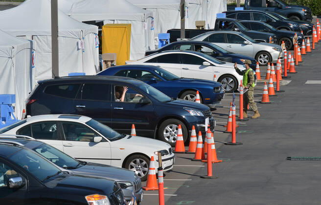 Military personnel administer COVID-19 shots to local residents at a drive-through vaccination site on the Cal State LA campus in Los Angeles on Thursday, March 4, 2021. California will begin sending 40% of all vaccine doses to the most vulnerable neighborhoods in the state to try to inoculate people most at risk from the coronavirus and get the state s economy open more quickly, Gov. Gavin Newsom said Thursday in the latest shake-up to the state s rules.  LAP2021030414 JIMxRUYMEN