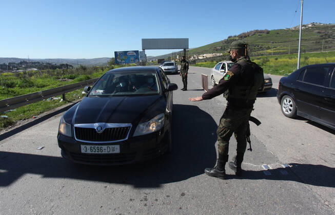 (210306) -- NABLUS, March 6, 2021 -- Palestinian police officers work at a checkpoint in the West Bank city of Nablus, March 6, 2021. Nablus Governor Ibrahim Ramadan announced on Thursday a total lockdown in his governorate for one week, starting Saturday, which includes a ban on movement of vehicles and closure of all shops and industries. Also on Thursday, Palestine extended its coronavirus-related state of emergency by a month following an increase in confirmed COVID-19 cases. (Photo by Xinhua) MIDEAST-NABLUS-COVID-19-LOCKDOWN NidalxEshtayeh 