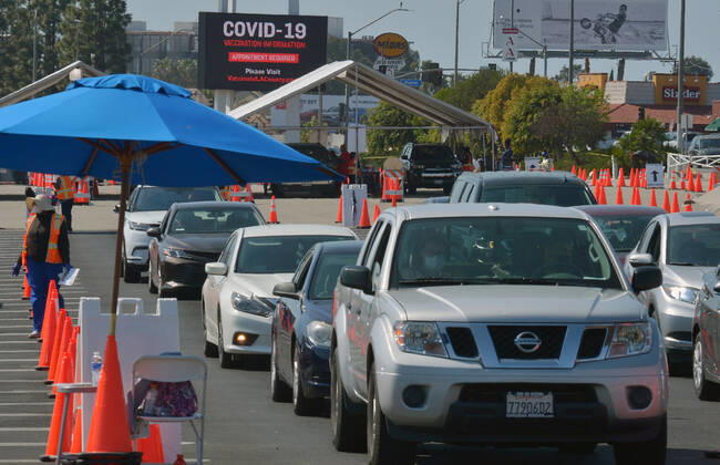 Drivers remain in their vehicles while being monitored to ensure they suffer no adverse reaction to the COVID-19 Moderna vaccine they received at the Forum in Inglewood, California on Saturday, March 6, 2021. As more Californians get vaccinated, the state will make it easier for counties to reopen, Newsom administration officials announced this week. Once 2 million coronavirus vaccines have been given to people in the state s most disadvantaged ZIP codes, the California Department of Public Health will lower the threshold for counties to move from the most restrictive purple tier into the less restrictive red tier.  LAP2021030602 JIMxRUYMEN