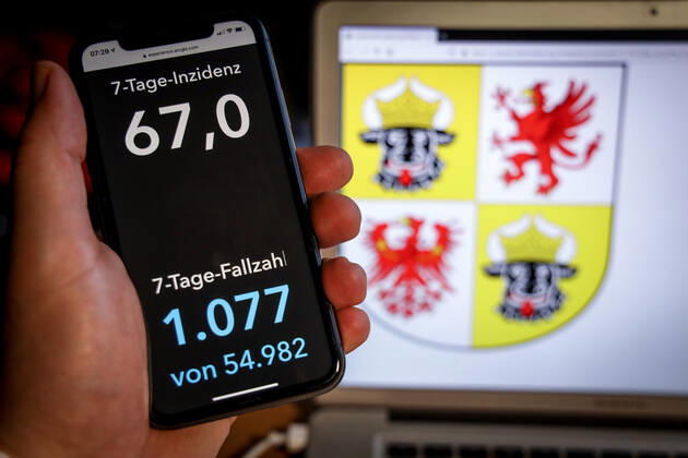 Coronavirus in Deutschland - Covid-19-Dashboard des Robert Koch-Institut DEU, Deutschland, Mecklenburg-Vorpommern, 07.03.2021: Die 7-Tage-Inzidenz für das Bundesland (Fälle letzte 7 Tage 100.000 EW) wird auf einem iPhone angezeigt, im Hintergrund das Landeswappen