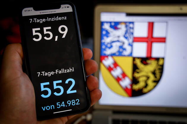 Coronavirus in Deutschland - Covid-19-Dashboard des Robert Koch-Institut DEU, Deutschland, Saarland, 07.03.2021: Die 7-Tage-Inzidenz für das Bundesland (Fälle letzte 7 Tage 100.000 EW) wird auf einem iPhone angezeigt, im Hintergrund das Landeswappen