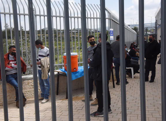 Palestinian workers wait fifteen minutes after receiving the first dose of the Moderns COVID-19 vaccine at the Lamed Hei Checkpoint between Gush Etzion and Beit Shemesh, on Monday, March 8, 2021. Israel started a two week campaign to vaccine some 100,000 Palestinian workers from the West Bank who hold permits to work in Israel and Jewish settlements. The vaccination campaign is a joint project by the Israeli Heath Ministry, Ministry of Defense, Land Crossing Authority and the Coordination of Government Activities in the Territories.  JER2021030813 DEBBIExHILL