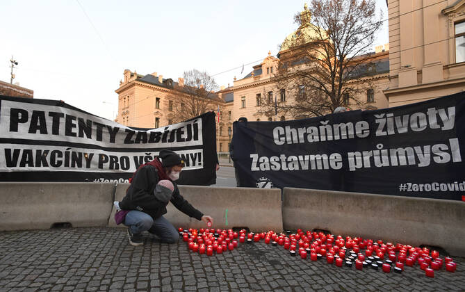 A woman, wearing respirator to prevent the spread of the coronavirus, lays down candle during the rally of group Let Us Stop COVID called Let Us Save Lives, Let Us Stop Industry in front of the Government Office in Prague, Czech Republic, March 9, 2021. (CTKxPhoto MichaelaxRihova) CTKPhotoP202103090776001  mir 2