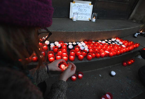 A woman, wearing respirator to prevent the spread of the coronavirus, lays down candle during the rally of group Let Us Stop COVID called Let Us Save Lives, Let Us Stop Industry in front of the Government Office in Prague, Czech Republic, March 9, 2021. (CTKxPhoto MichaelaxRihova) CTKPhotoP202103090785001  mir 4