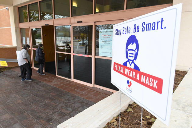 Patrons wear masks at a public library in Plano, Texas on Tuesday, March 9, 2021. Texas Gov. Greg Abbott fully rescinded the statewide mask order and is allowing business to reopen at full capacity effective March 10, 2021 leaving organizations and businesses to determine if they want to require customers to wear masks or not.  DAL2021030909 IANxHALPERIN
