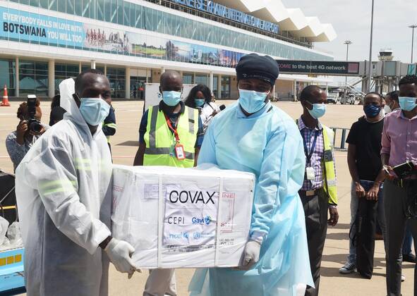 (210310) -- GABORONE, March 10, 2021 -- Staff carry a box of COVID-19 vaccines at the Sir Seretse Khama International Airport in Gaborone, Botswana, March 9, 2021. Botswana received the first batch of 30,000 doses of COVID-19 vaccines donated by India on Tuesday. (Photo by Xinhua) BOTSWANA-GABORONE-COVID-19 VACCINE-ARRIVAL TshekisoxTebalo 