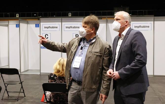 Erfurt - Eröffnung Impfzentrum 10.03.2021 , Erfurt, Messehalle, Impfzentrum Mittelthüringen, Eröffnung des Impfzentrums durch Oberbürgermeister Andreas Bausewein und Vertretern der Kassenärztlichen Vereinigung im Bild: Dr.med. Sakriss (KV) zeigt Oberbürgermeister Andreas Bausewein das Impfzentrum, im Hintergrund die Impfkabinen