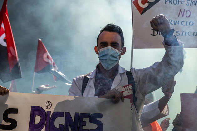 March 10, 2021, Barcelona, Catalonia, Spain: A protester at Plaza Sant Jaume raising his fist amid smoke during the demonstration..Under the slogan estemfartes (we are fed up), the Catalan Health Union Board, formed by minority unions, has mobilized health workers to a day of strike to denounce the physical fatigue of health professionals and salary cuts. Barcelona Spain - ZUMAs197 20210310_zaa_s197_157 Copyright: xPacoxFreirex