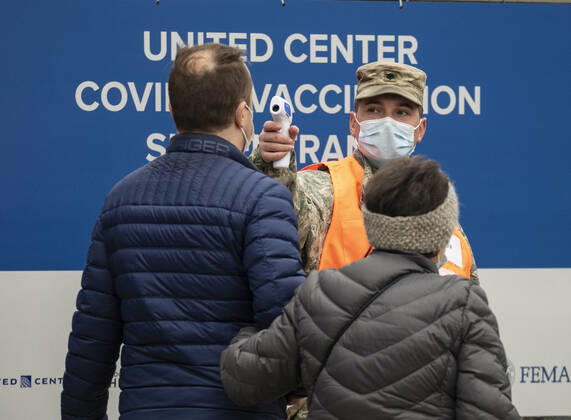 (210310) -- CHICAGO, March 10, 2021 -- A man has his temperature taken before entering a mass COVID-19 vaccination site at the United Center in Chicago, the United States, on March 10, 2021. The mass COVID-19 vaccination site started running at the arena on Tuesday. (Photo by Xinhua) U.S.-CHICAGO-MASS VACCINATION SITE-OPENING JoelxLerner 