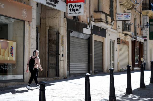 (210311) -- VALLETTA, March 11, 2021 -- A pedestrian walks past closed stores in Valletta, Malta, March 11, 2021. The Maltese government on Wednesday announced the closure of schools and non-essential shops in response to a spike in new COVID-19 cases, almost two-thirds of which are attributable to the variant first reported in the UK. The new measures, which will be in force until April 11, include the closure of all non-essential shops and those providing non-essential services such as hairdressers and beauticians while the limitation of group gatherings in public down to a maximum of four people. (Photo by Xinhua) MALTA-VALLETTA-COVID-19-RESTRICTIONS JonathanxBorg 