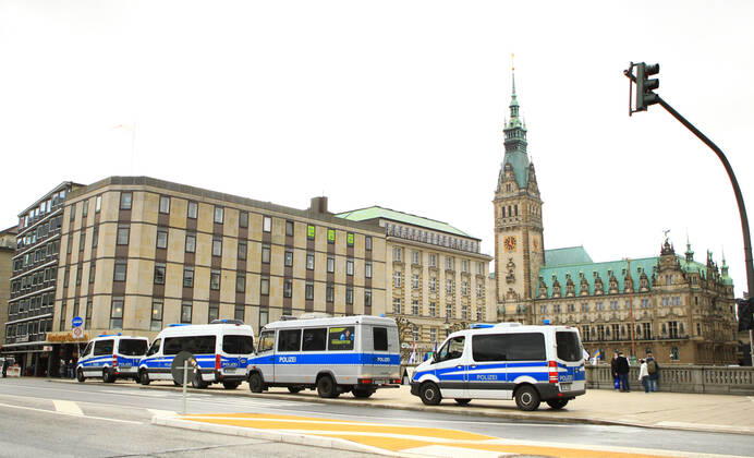 Einsatzwagen der Polizei stehen an der Reesendammbrücke am Hamburger Jungfernstieg. Im Hintergrund das Hamburger Rathaus. Die Polizeikräfte bereiten sich auf eine Demonstration von Kritikern der Corona-Politik der Bundesregierung vor, die auf dem Rathausplatz stattfinden wird. Innenstadt Hamburg