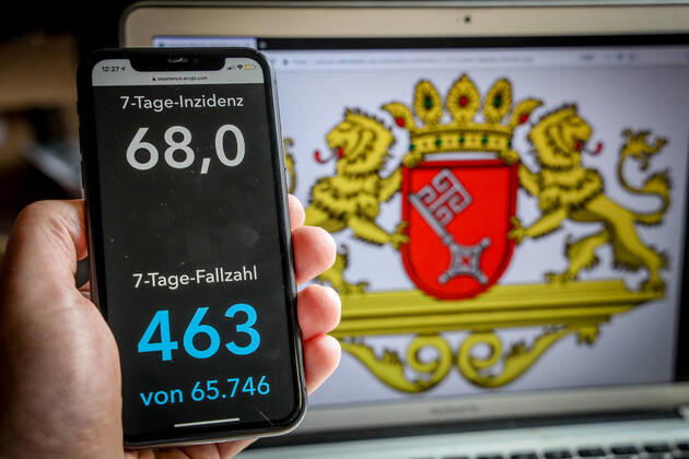 Coronavirus in Deutschland - Covid-19-Dashboard des Robert Koch-Institut DEU, Deutschland, Bremen, 14.03.2021: Die 7-Tage-Inzidenz für das Bundesland (Fälle letzte 7 Tage 100.000 EW) wird auf einem iPhone angezeigt, im Hintergrund das Landeswappen