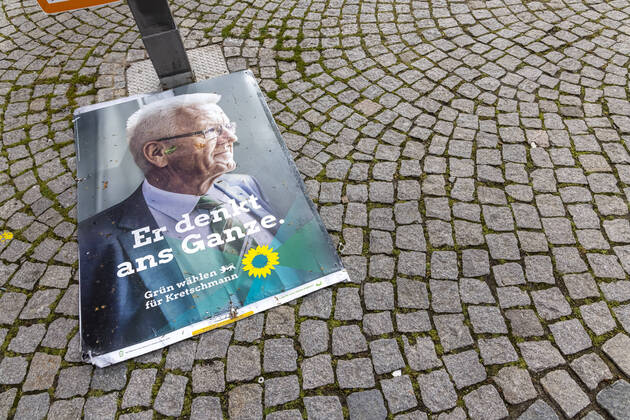 LTWBW21. Der Wind hat sich an Wahlplakaten abgearbeitet. Zahlreiche Plakate, wie hier eines von Ministerpräsident Winfried Kretschmann, liegt auf dem Asphalt. 14.03.2021: Deutschland, Baden-Württemberg, Stuttgart.