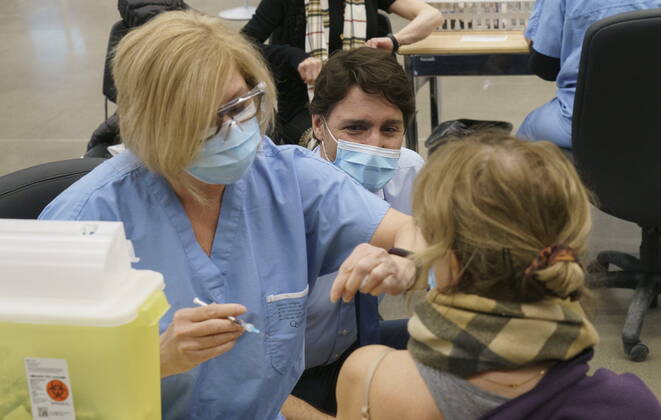 March 15, 2021, Montreal, PQ, Canada: Prime Minister Justin Trudeau watches a woman receive her COVID-19 vaccine while touring a vaccination clinic in Montreal on Monday, March 15, 2021. Montreal Canada  - ZUMAc35_ 20210315_zaf_c35_001 Copyright: xPaulxChiassonx