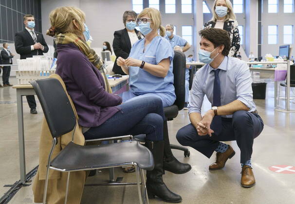 March 15, 2021, Montreal, PQ, Canada: Prime Minister Justin Trudeau chats with a woman about to receive her COVID-19 vaccine while touring a vaccination clinic in Montreal on Monday, March 15, 2021. Montreal Canada  - ZUMAc35_ 20210315_zaf_c35_002 Copyright: xPaulxChiassonx