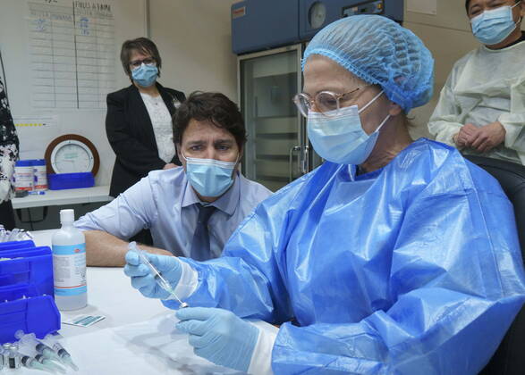 March 15, 2021, Montreal, PQ, Canada: Prime Minister Justin Trudeau watch as a COVID-19 vaccine syringe is prepared as he tours a vaccination clinic in Montreal, on Monday, March 15, 2021. Montreal Canada  - ZUMAc35_ 20210315_zaf_c35_005 Copyright: xPaulxChiassonx