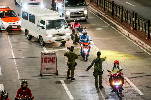 Coronavirus auf den Philippinen, Polizei überwacht Ausgangssperre (210315) -- MANILA, March 15, 2021 -- Policemen work at a checkpoint for passing motorists during the implementation of strict quarantine measures in Manila, the Philippines on March 15, 2021. Metro Manila, home to about 13 million people, started imposing strict quarantine measures again on Monday to contain a recent surge of coronavirus infections. The Philippines Department of Health (DOH) reported on Monday that 5,404 new coronavirus disease (COVID-19) infections, the highest daily tally in seven months, bringing the total number of confirmed cases in the country to 626,893. ) PHILIPPINES-MANILA-COVID-19-QUARANTINE MEASURES RouellexUmali