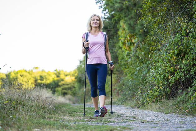 IMAGO Creative: Internationaler Frauenmonat, Gesundheit, Frauen in der Menopause Low angle view of smiling mature woman hiking in forest Copyright: FrédéricxCirou B88303246
