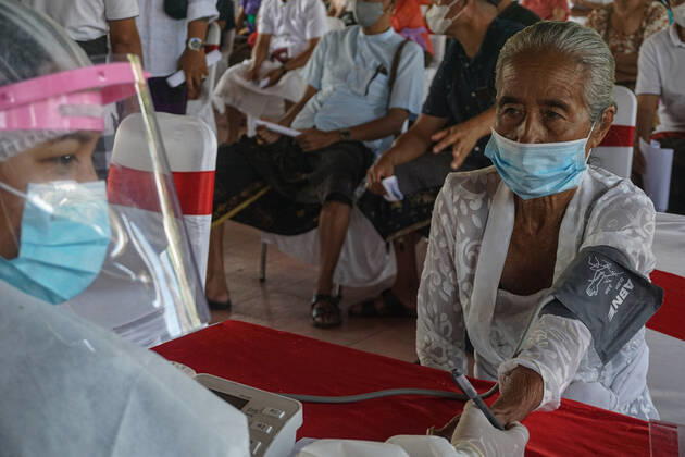 Coronavirus in Indonesien, Präsident Joko Widodo bei Impfstart in Gianyar, Bali March 16, 2021, Gianyar, Bali, Indonesia: A health worker checks a health condition of a citizen before the vaccination. A mass Covid-19 vaccination towards citizens held in Ubud Great Palace, as a stage of Green Zone program in Bali. The Green Zone program involves three region in Bali; Ubud, Sanur and Nusa Dua, are sets to prepare international tourism reopening plan, which falls amid the outbreak. Gianyar Indonesia - ZUMAb245 20210316_zip_b245_001 Copyright: xDickyxBisinglasix