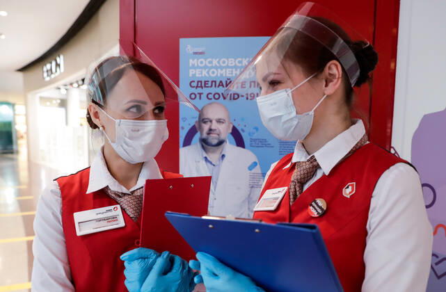 MOSCOW, RUSSIA - MARCH 17, 2021: My Documents public service centre employees wear face shields at a temporary COVID-19 vaccination site, a mobile team administering the Gam-COVID-Vac (Sputnik V) vaccine free of charge and without prior appointment at the Kuntsevo Plaza shopping centre in western Moscow. Mikhail Metzel TASS  TS0F99AC