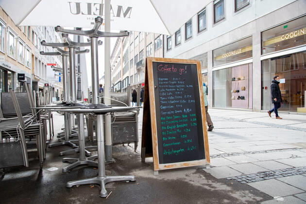 Coronavirus Situation in Bayern, Hochgeklappte Stühle und TIsche, aber Coffe to go. Menschen shoppen in München am 18.3.2021. - People go shopping in Munich, Germany on March 18 2021. München Bayern Deutschland