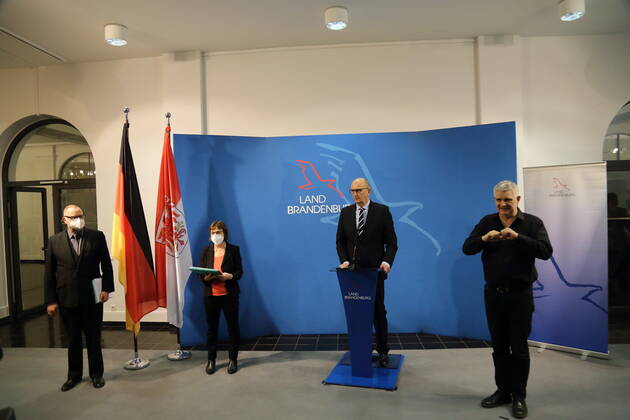Innenminister Michael Stübgen (CDU), Gesundheitsministerin Ursula Nonnemacher (Bündnis 90 Die Grünen), Ministerpräsident Dietmar Woidke (SPD) und Gebärdensprachdolmetscher Uwe Schönfeld, v.l., während einer Pressekonferenz zu verschärften Maßnahmen zur Eindämmung der Coronavirus-Pandemie auf Landkreisebene, Staatskanzlei, Potsdam, 18. März 2021. Brandenburg Coronavirus PK
