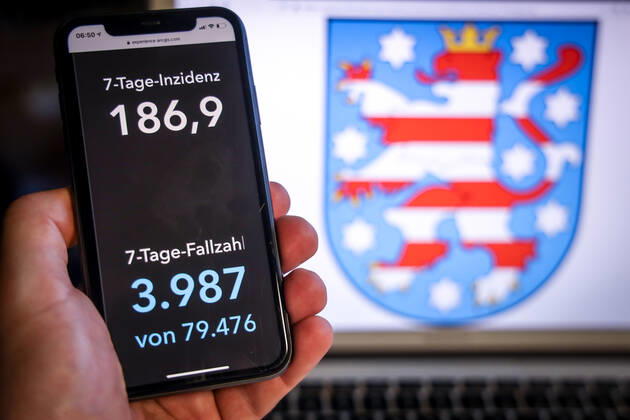 Coronavirus in Deutschland - Covid-19-Dashboard des Robert Koch-Institut DEU, Deutschland, Thüringen, 19.03.2021: Die 7-Tage-Inzidenz für das Bundesland (Fälle letzte 7 Tage 100.000 EW) wird auf einem iPhone angezeigt, im Hintergrund das Landeswappen
