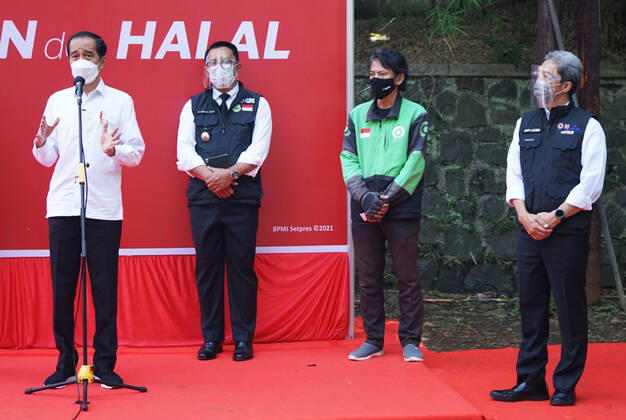 President Joko Widodo Reviewing Drive Thru Vaccination In Bogor, Indonesia Indonesian President Joko Widodo (left) with West Java Governor Ridwan Kamil (left two) and Vice Mayor of Bogor City Dedie Rachim (right) speaks to journalists during COVID-19 vaccination at a drive-thru service in Bogor City, West Java, Indonesia on March 19, 2021. President Joko Widodo hopes that other region in Indonesia will be able to imitate the drive thru vaccination model in Bogor City. 