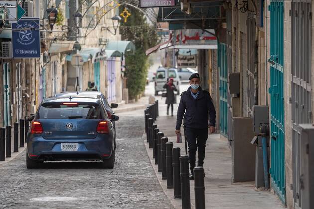 (210320) -- BETHLEHEM, March 20, 2021 -- A Palestinian police officer walks by closed shops in the West Bank city of Bethlehem, March 20, 2021. The Governor of Bethlehem announced on Thursday the closure of the governorate and a ban on all activities from Thursday evening until Sunday morning due to increasing numbers of COVID-19 infection. (Photo by Xinhua) MIDEAST-BETHLEHEM-COVID-19-LOCKDOWN LuayxSababa 