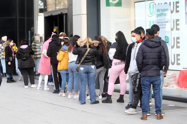 Eine lange Schlang von Kunden steht vor dem Eingang zu einem Modegeschäft in der Fußgängerzone und Einkaufsstraße Zeil, um Einlass zu erhalten, Frankfurt, Hessen, Deutschland
