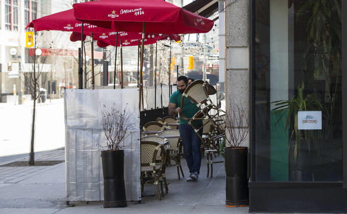 (210320) -- TORONTO, March 20, 2021 -- A waiter wearing a face mask prepares chairs for customers at the outdoor area of a restaurant in Toronto, Canada, on March 20, 2021. With distancing rules and a number of other public health and workplace safety measures, outdoor dining was allowed to resume Saturday in Toronto under modifications to the Ontario s color-coded pandemic response framework. (Photo by Xinhua) CANADA-TORONTO-COVID-19-OUTDOOR DINING-RESUME ZouxZheng 