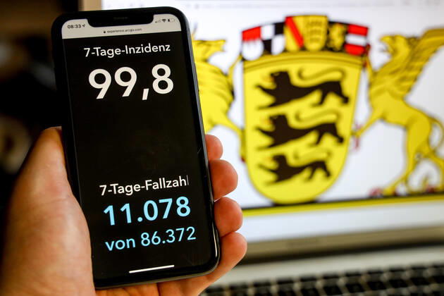 Coronavirus in Deutschland - Covid-19-Dashboard des Robert Koch-Institut DEU, Deutschland, Baden-Württemberg, 21.03.2021: Die 7-Tage-Inzidenz für das Bundesland (Fälle letzte 7 Tage 100.000 EW) wird auf einem iPhone angezeigt, im Hintergrund das Landeswappen
